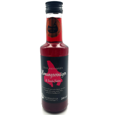 Vinäger Honung och Svarta Vinbär 3 en flaska mörkröd genomskinlig honungsvinäger med svarta vinbär. Flaskan bär etiketten "svenska mästerskapen i mathantverk Eldrimner 2025 - Brons"