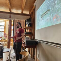 Thomas står framför en presentation med titeln "svampodling"