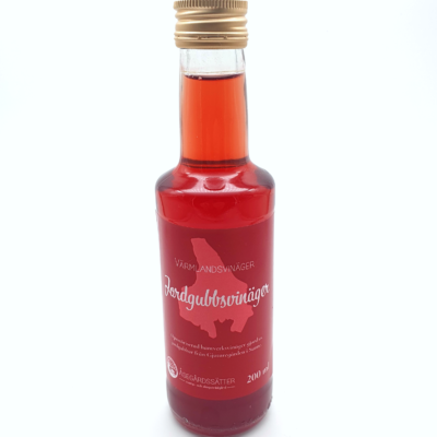 en flaska röd genomskinlig jordgubbsvinäger